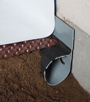 Closeup of a crawl space drainage system installed in Mason City