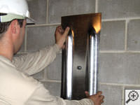 Mounting a foundation wall plate for an earth anchor installation in Grand Forks.