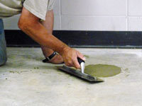 Repairing the cored holes in the concrete slab floor with fresh concrete and cleaning up the Eden Prairie home.