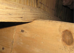 A failing girder showing signs of compression damage in a Minnesota, North Dakota, Iowa, and Wisconsin home