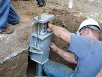 Foundation repair contractors installing the foundation bracket in Rochester.