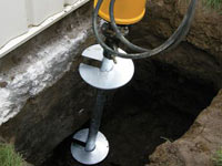 Installing a helical pier system in the earth around a foundation in St. Paul