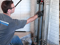 Driving foundation piers into the floor in Grand Forks.