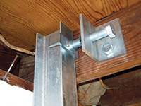Securing the i-beam system to the top of the floor joist in a foundation wall repair in Eden Prairie.