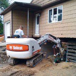 Excavating to expose the foundation walls and footings for a replacement job in Grand Forks
