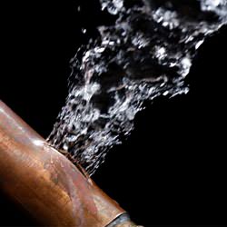 A bursting copper pipe in St. Paul, with water gushing out.