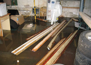 A severely flooding basement in Eden Prairie, with lumber and personal items floating in a foot of water
