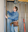 Insulated basement wall panels being placed against a concrete foundation wall in Eau Claire